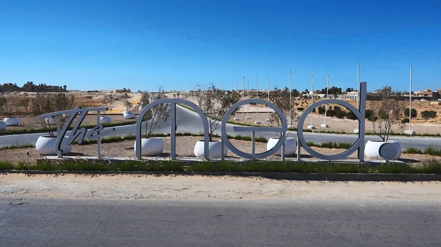 The Med entrance signage surrounded by the development landscape under a clear blue sky