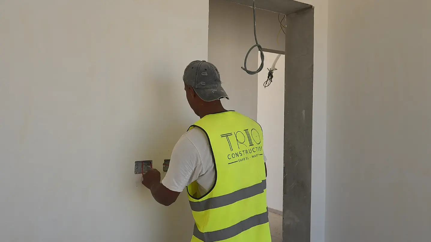 Trio Construction team member working on electrical installations inside a residential unit at The Med