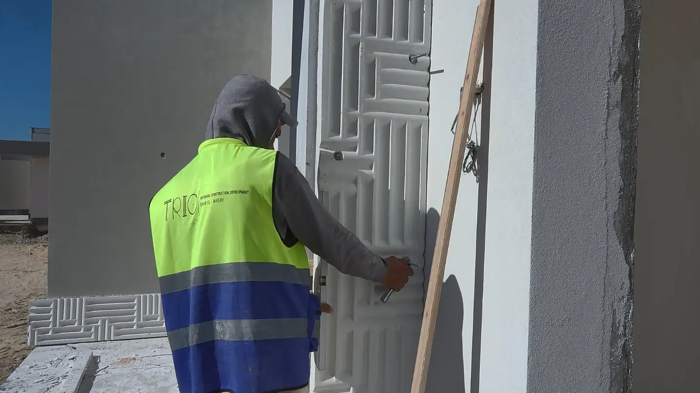 Trio Construction worker installing and finishing an exterior architectural door at The Med